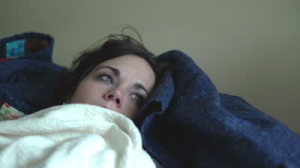 stock-footage-sick-girl-laying-on-couch-blows-nose